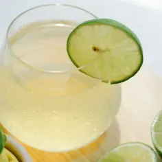 Szklanka orzeźwiającego napoju z plasterkiem limonki. Czy wiesz, jakie są przyczyny gorzkiego posmaku po wyciśnięciu limonki praską?