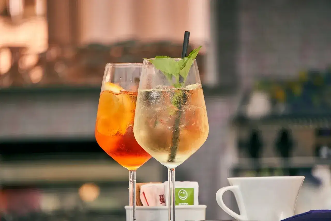 Dwa drinki, jeden pomarańczowy, drugi jasny, z lodem i miętą. Mogą być oznaką utraty aromatu przez otwarte likiery owocowe.