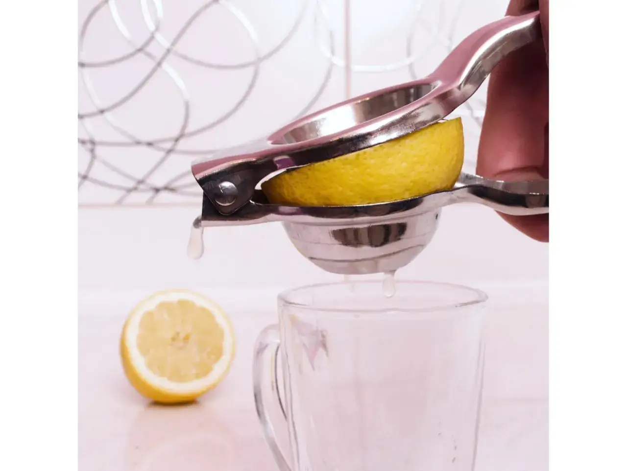 Praska do cytrusów wyciska sok z limonki. Gorzki posmak po wyciśnięciu limonki praską może wynikać z uszkodzenia białej części skórki.